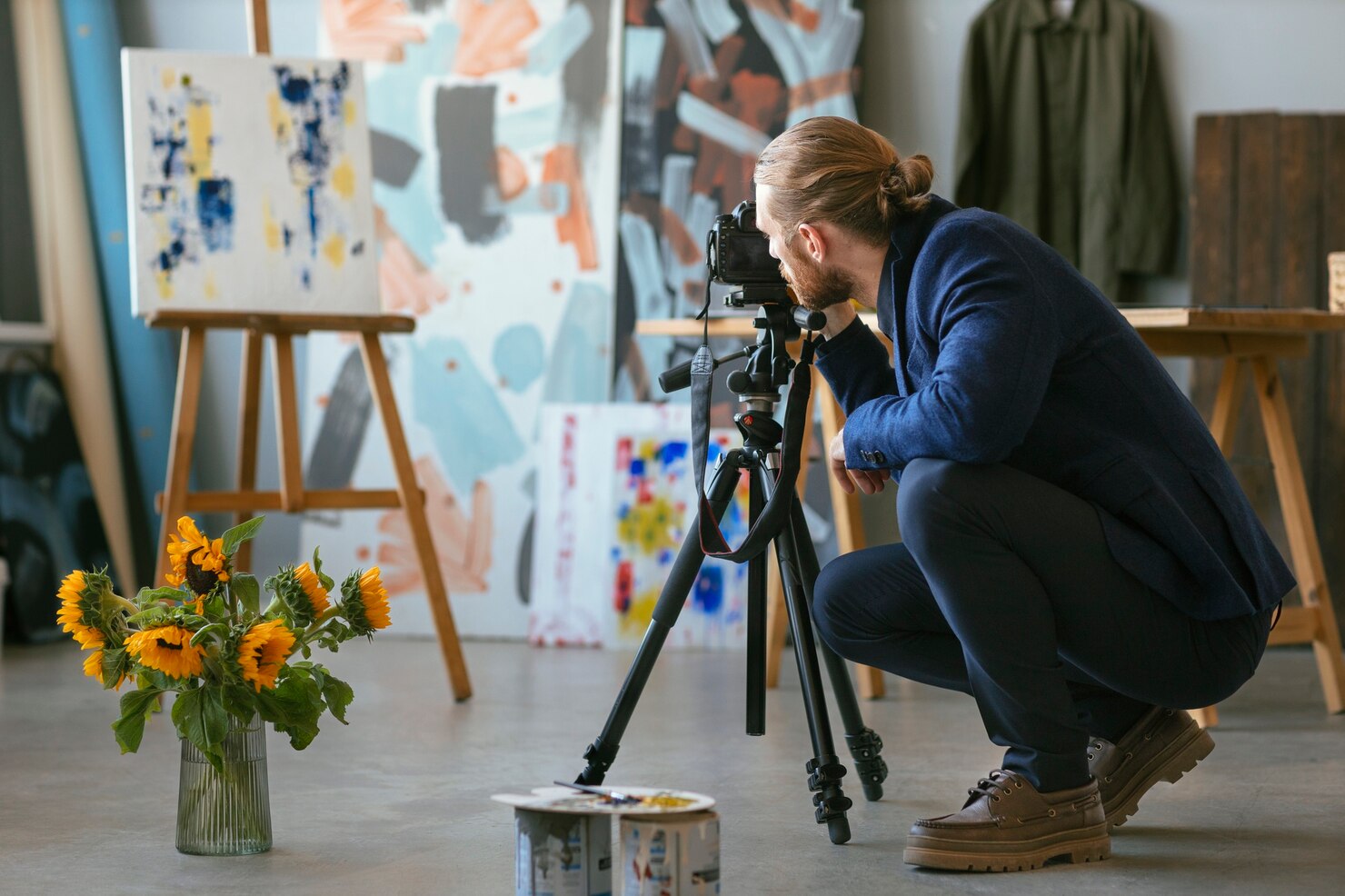 Professional photographer documenting artwork in a studio, symbolizing investment in creative industries and Saudi Culture & Arts.