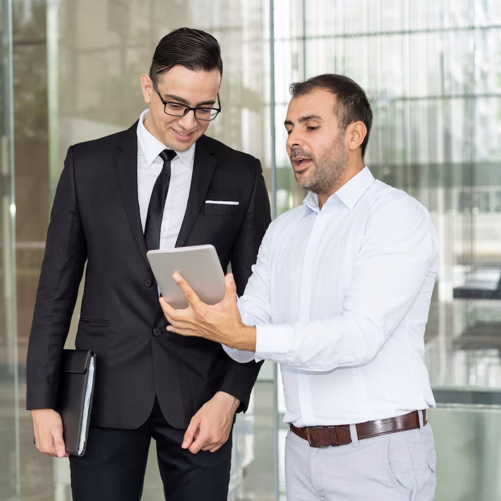 Commercial professionals discussing business strategies using a digital tablet.