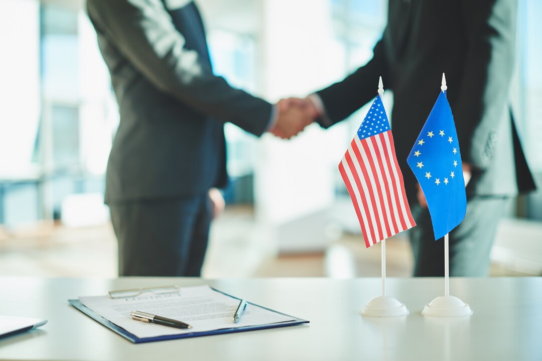 Brokerage agreement between international partners with USA and EU flags on table.