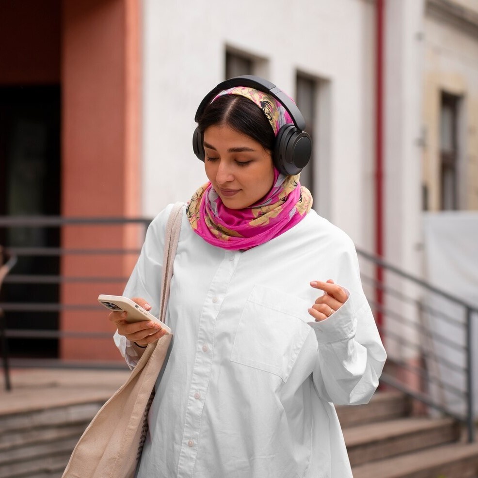Young woman with headphones and smartphone exploring a city, representing modern Tourism and Hospitality experiences.