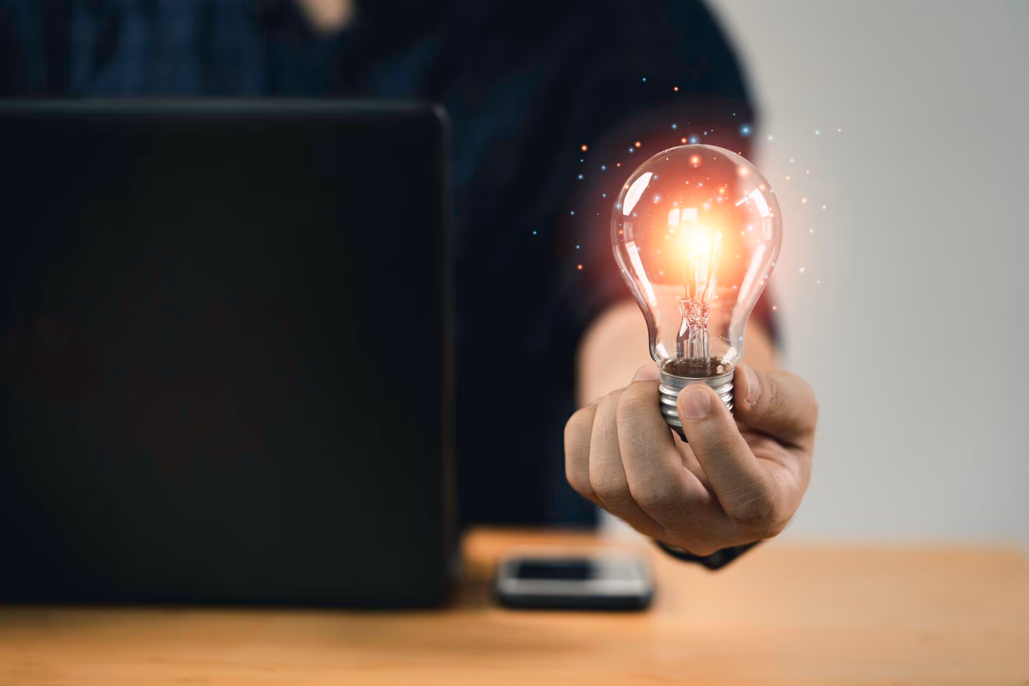 Advisory expert holding a glowing light bulb symbolizing innovation and strategic insight at Nuwa Partners.