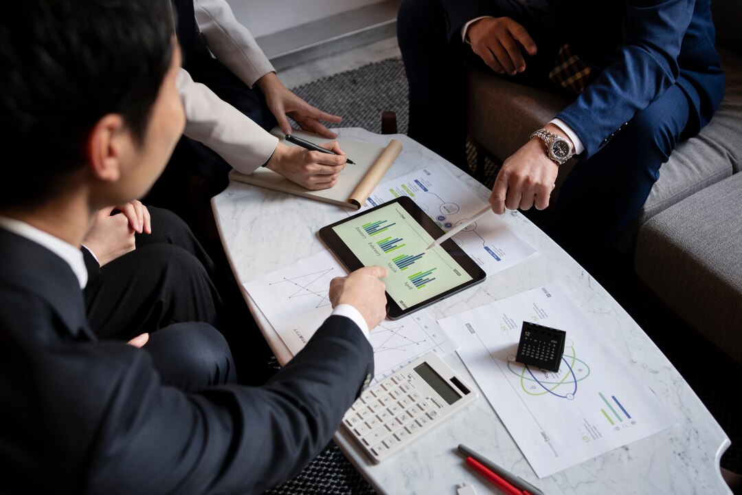 Brokerage experts discussing investment performance and analyzing data on a digital tablet.